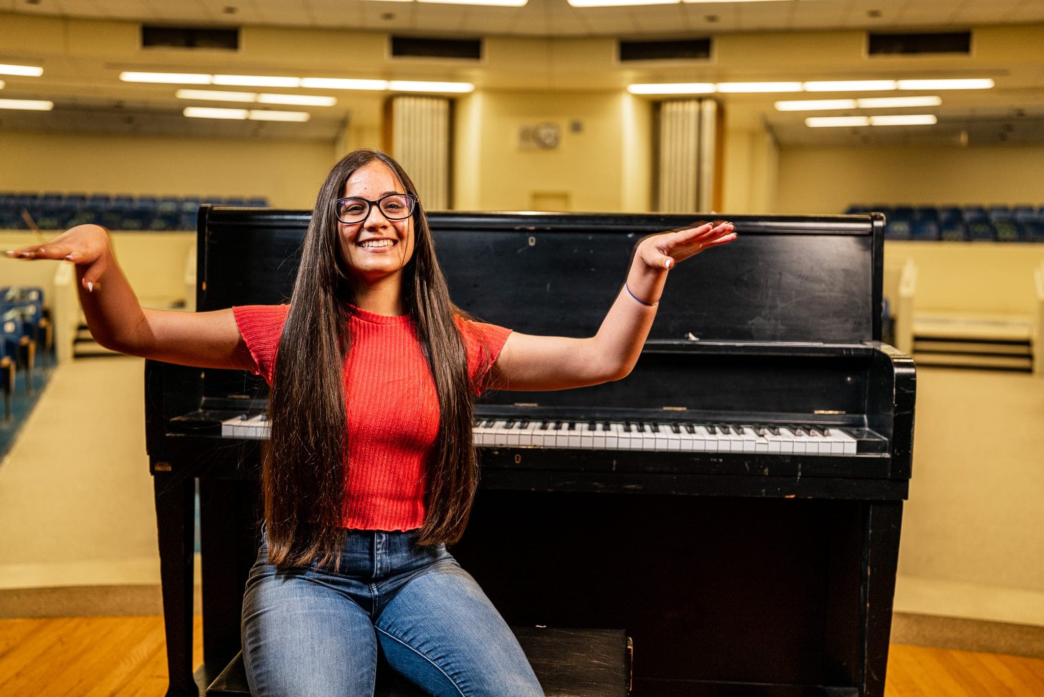 A performer on stage in an empty auditorium — the screening-room scale StoryRoom is built for