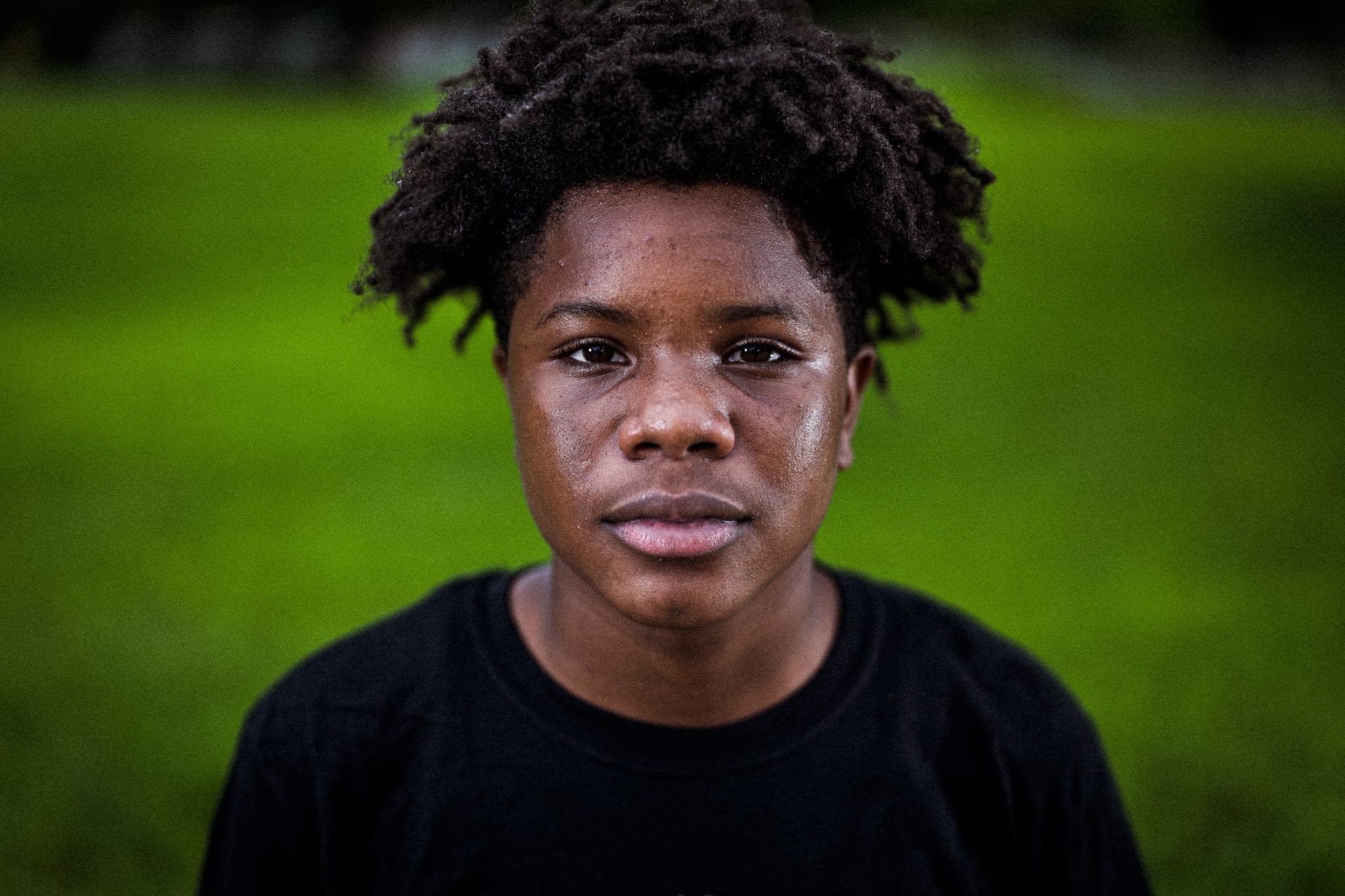 A person standing in tall grass — the range of campus and field stories a university tells